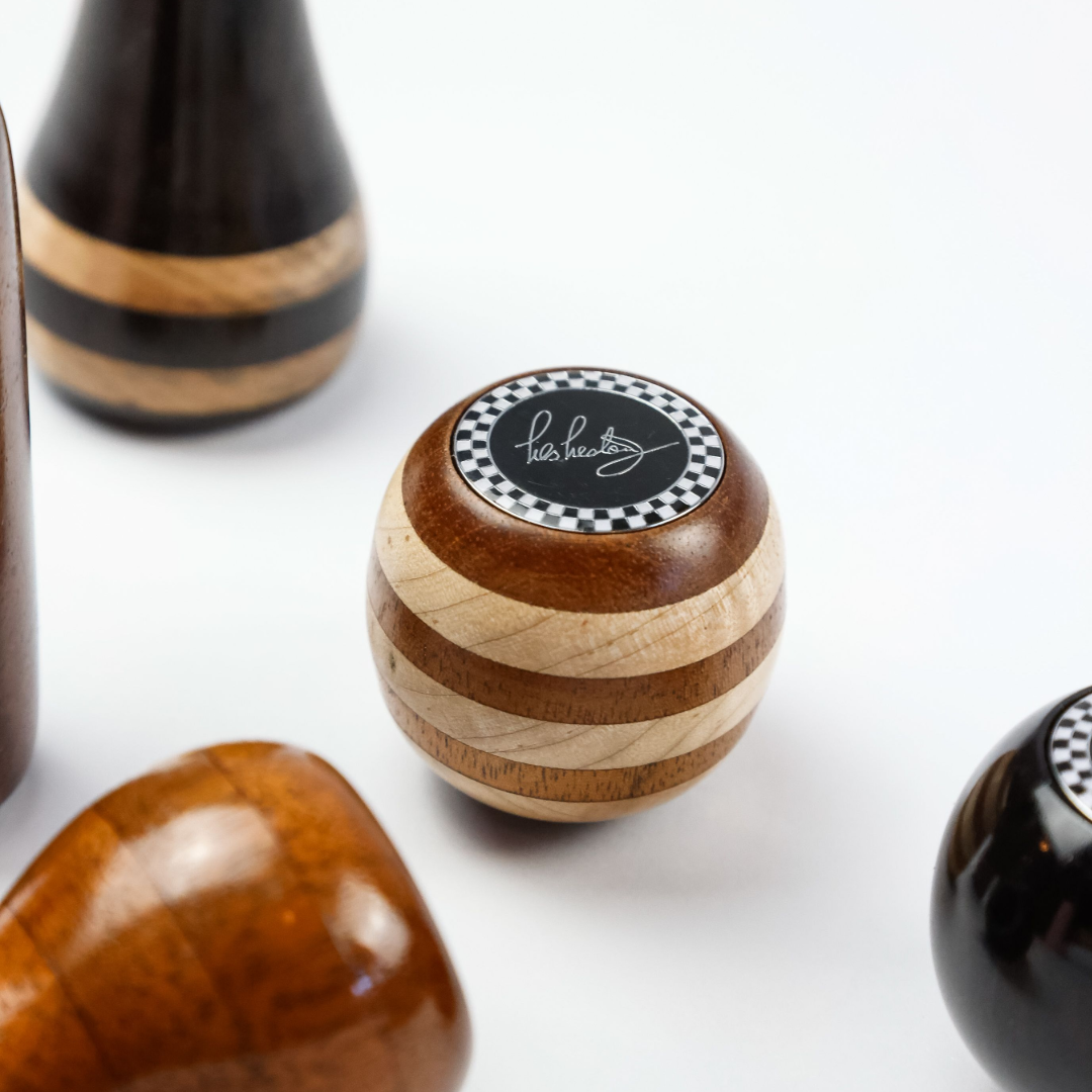 Close up of Les Leston Brooklands wooden gear knob handcrafted in England showing the distinctive striped beech and mahogany wood grain with a hand finished period correct design for classic sports cars, GT cars and historic racing vehicles