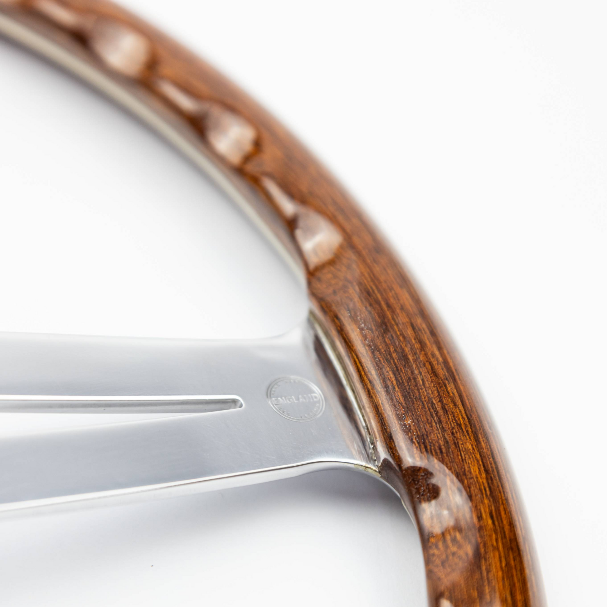 Close-up view of finger slot detail on 15-inch Les Leston Monte Carlo steering wheel rim showing ergonomic grip cut-outs, wood finish, and period-correct racing design