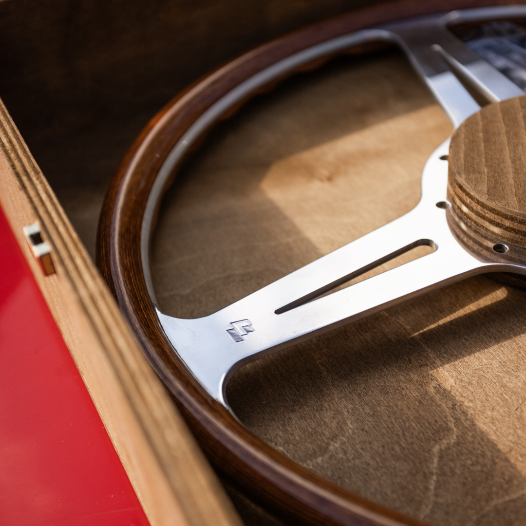 Close up of Les Leston wooden steering wheel displayed in a handcrafted wooden presentation box showing the premium finish and period correct craftsmanship