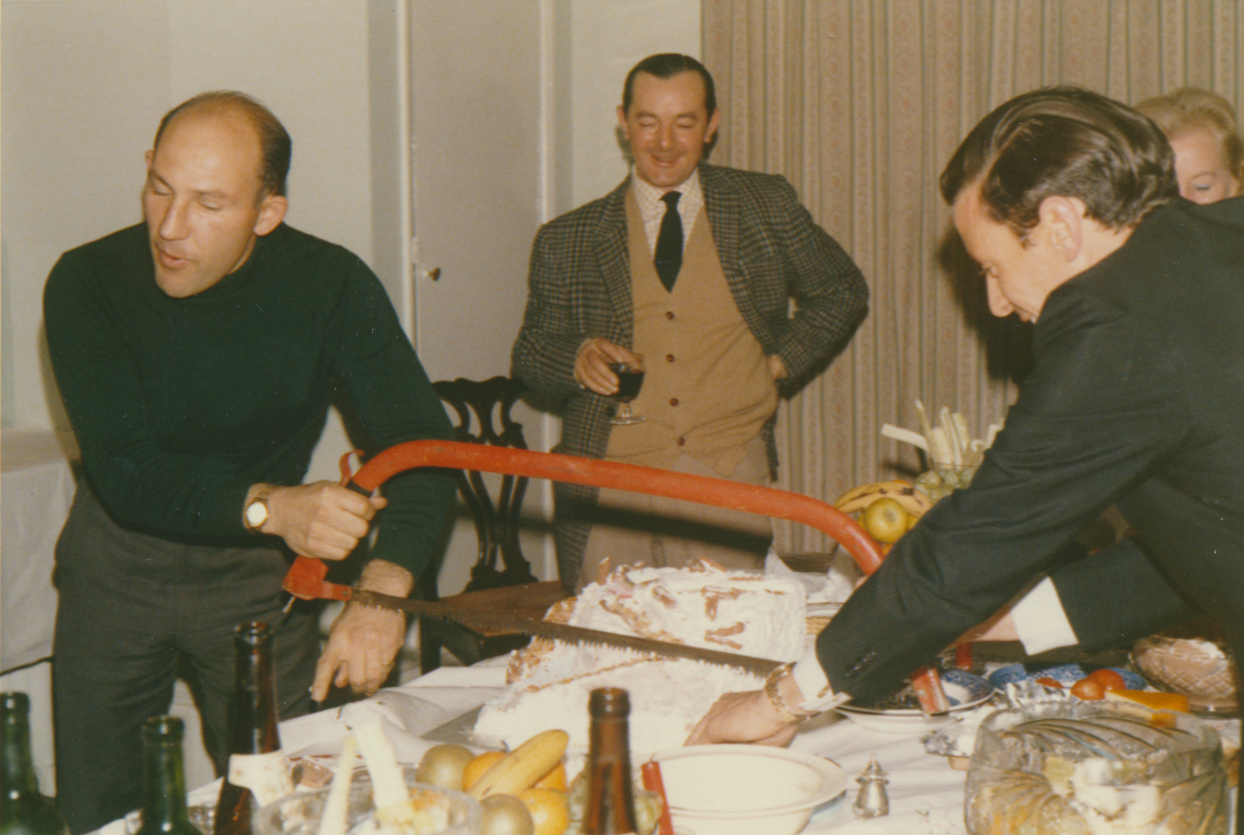 Jim Clark and Stirling Moss cutting a birthday cake together at Les Leston’s cottage in historic motorsport photograph