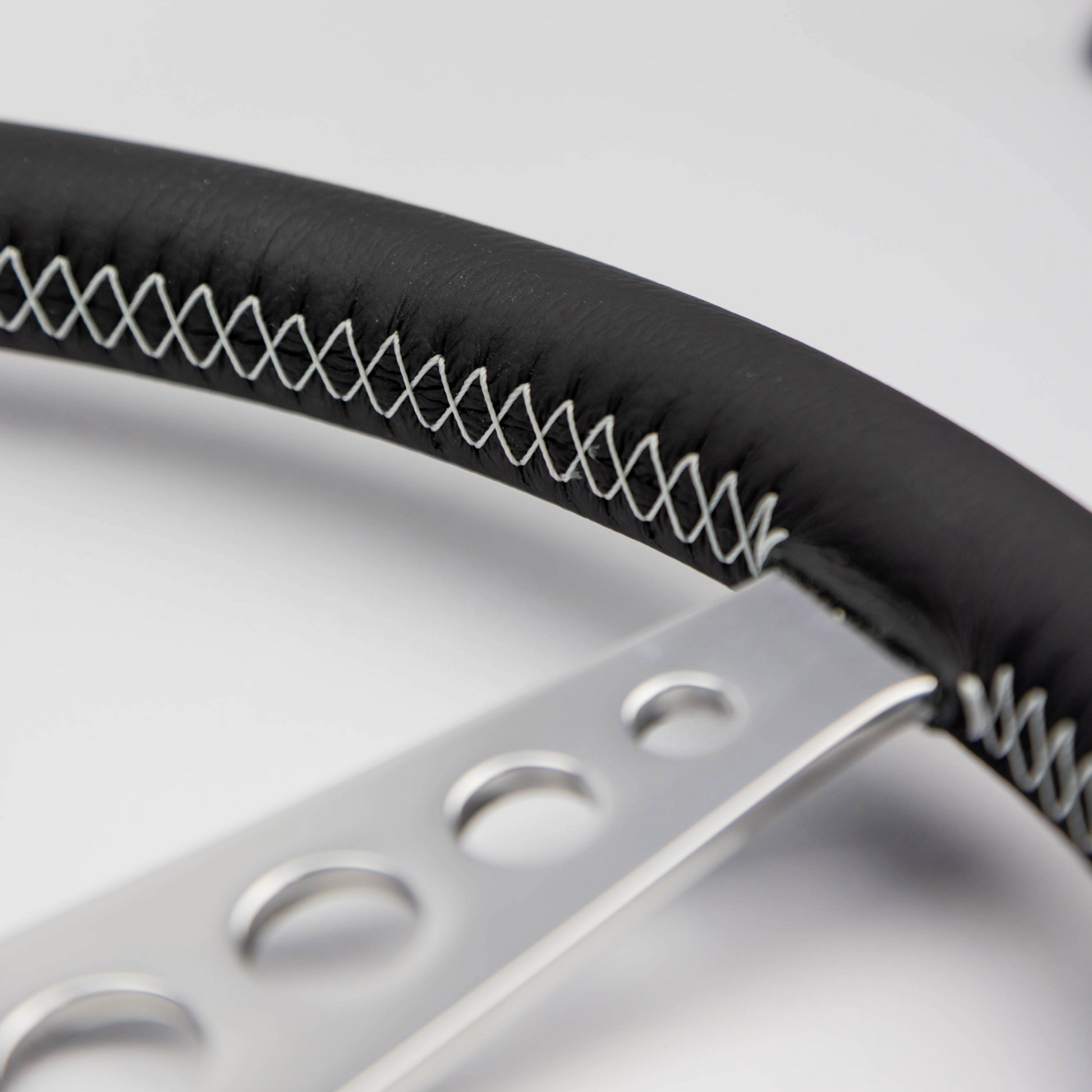 Close-up of the hand-finished black leather rim on a Les Leston 14-inch dished steering wheel