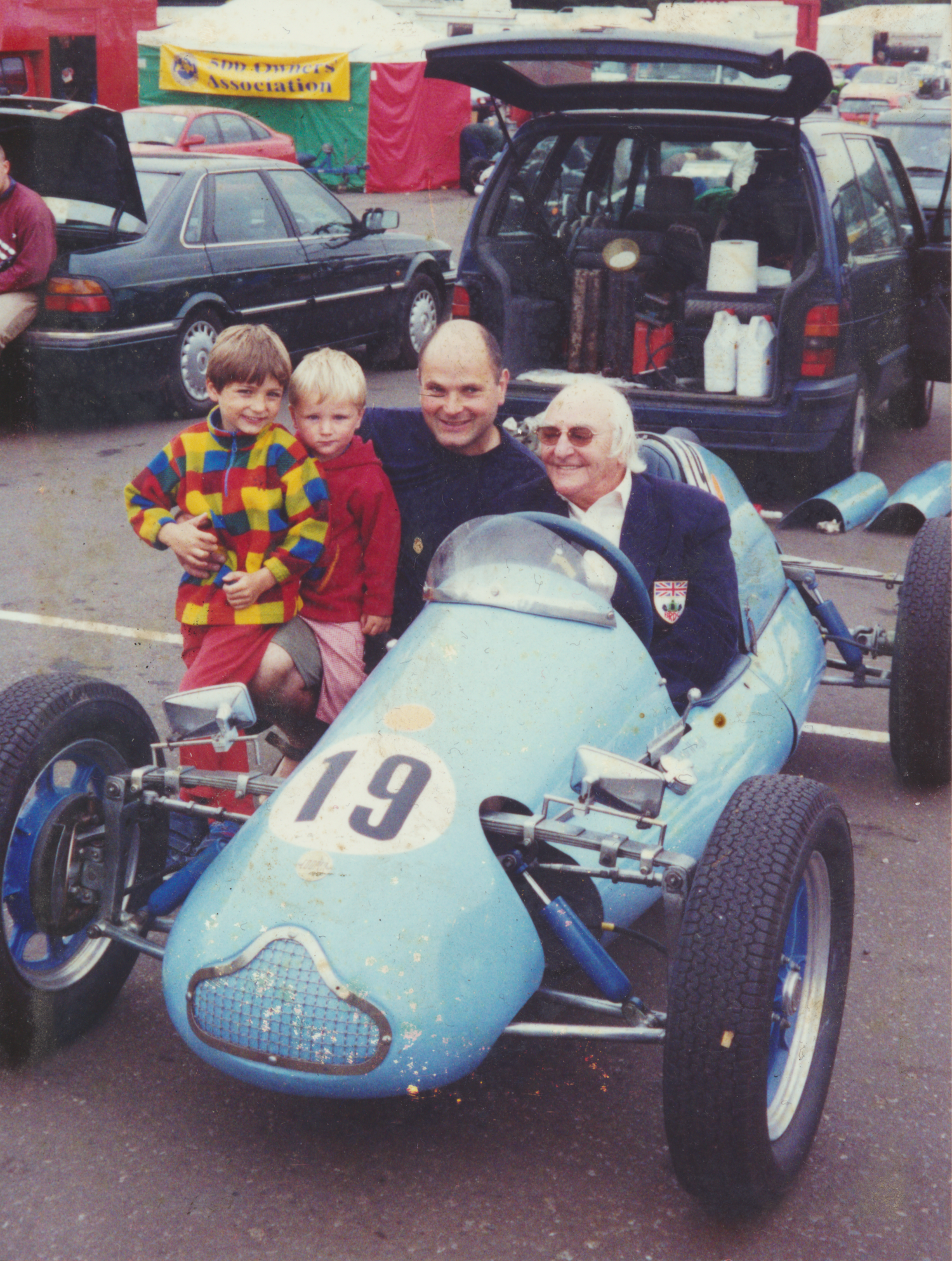Les Leston with family in later years seated in Cooper 500cc racing car during historic motorsport gathering